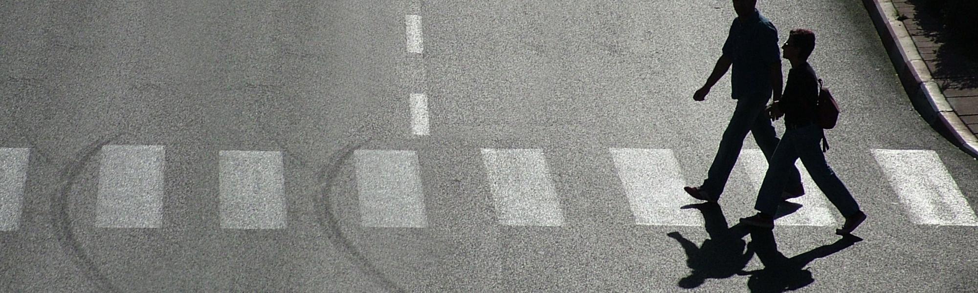 two people crossing the road zebra crossing