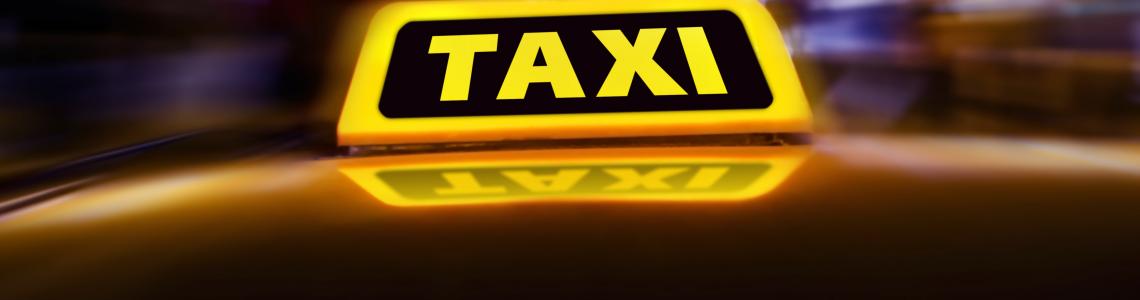 Taxi_sign_on_the_roof_of_car_on_the_street_at_night