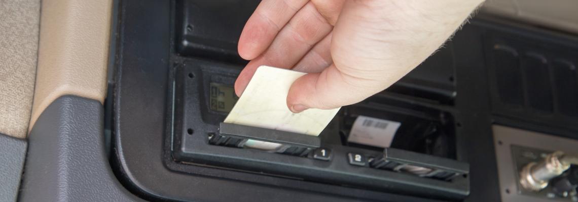 truck driver who inserts tachograph card to the device inside the truck cab