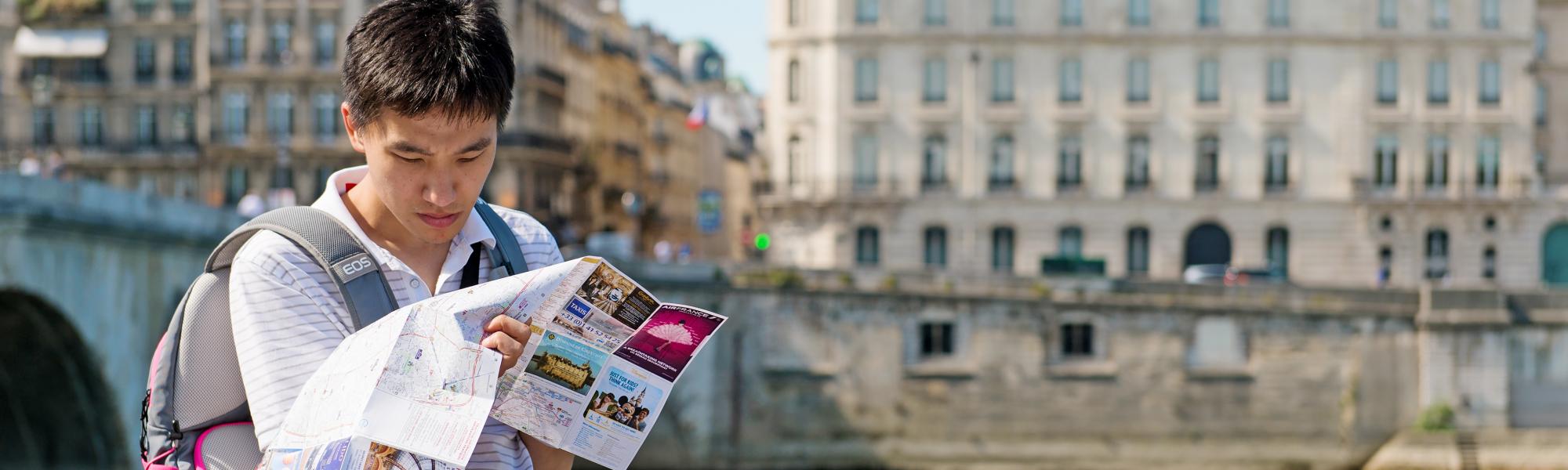 Asian tourist consulting a map