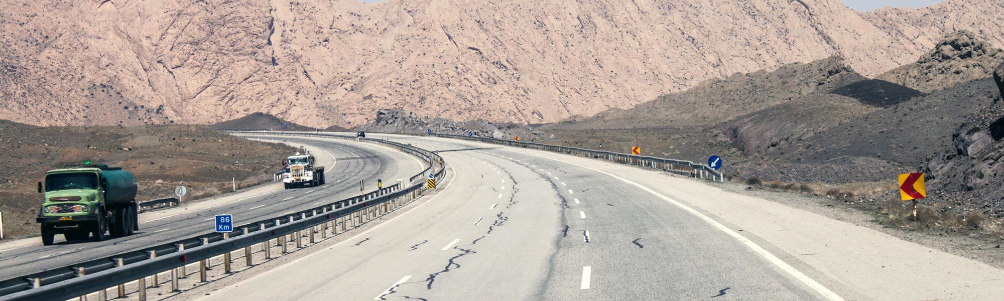 road near Tehran with trucks and road signs