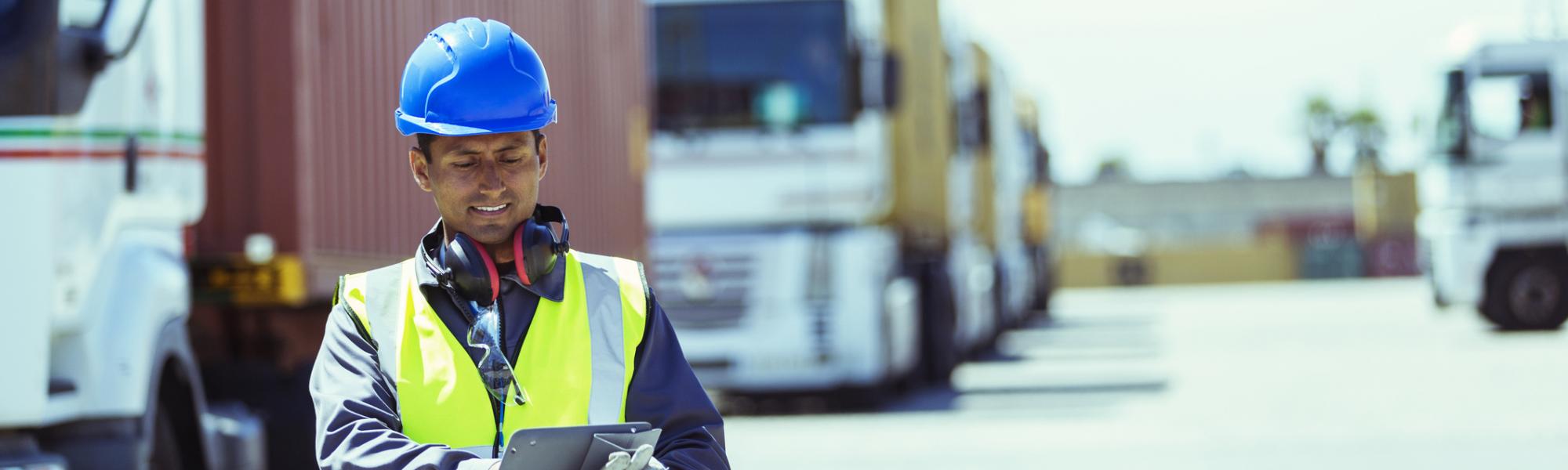 man with tablet shipping containers