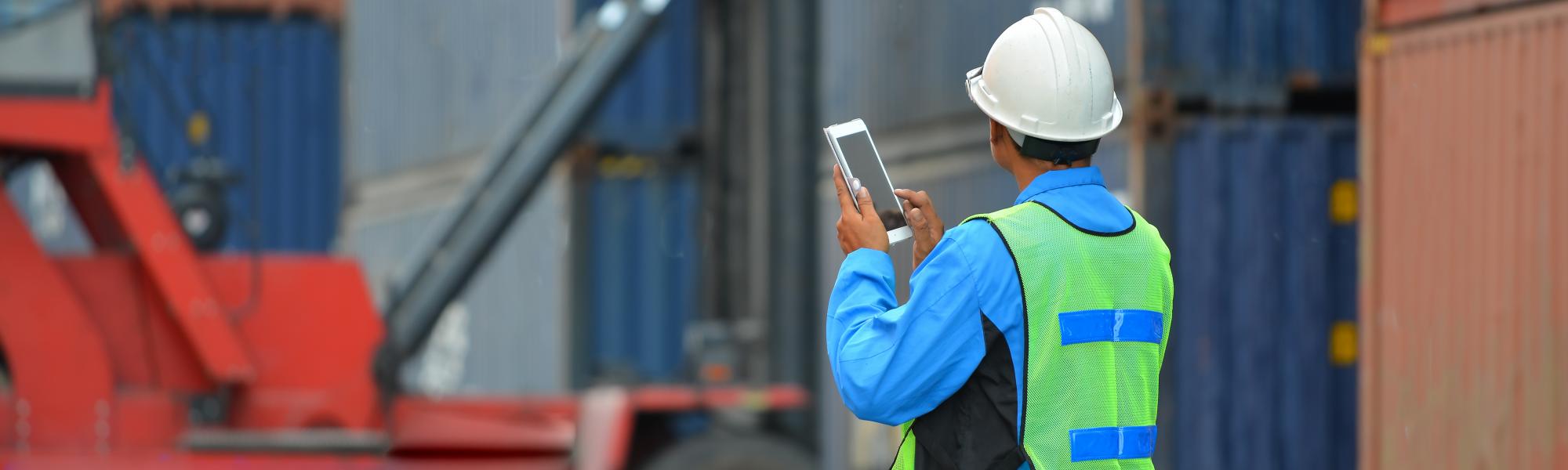 man with tablet and shipping containers