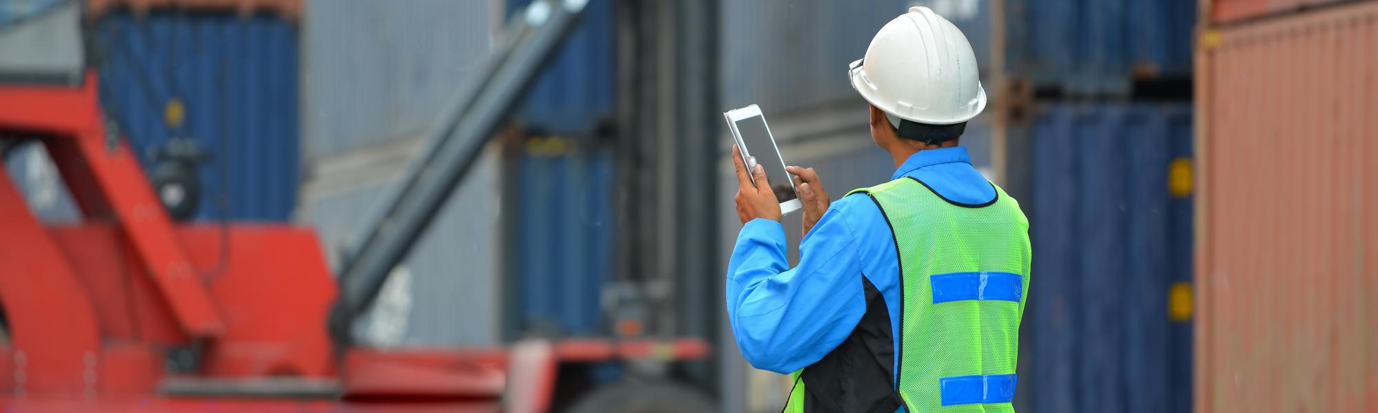 man with tablet shipping containers