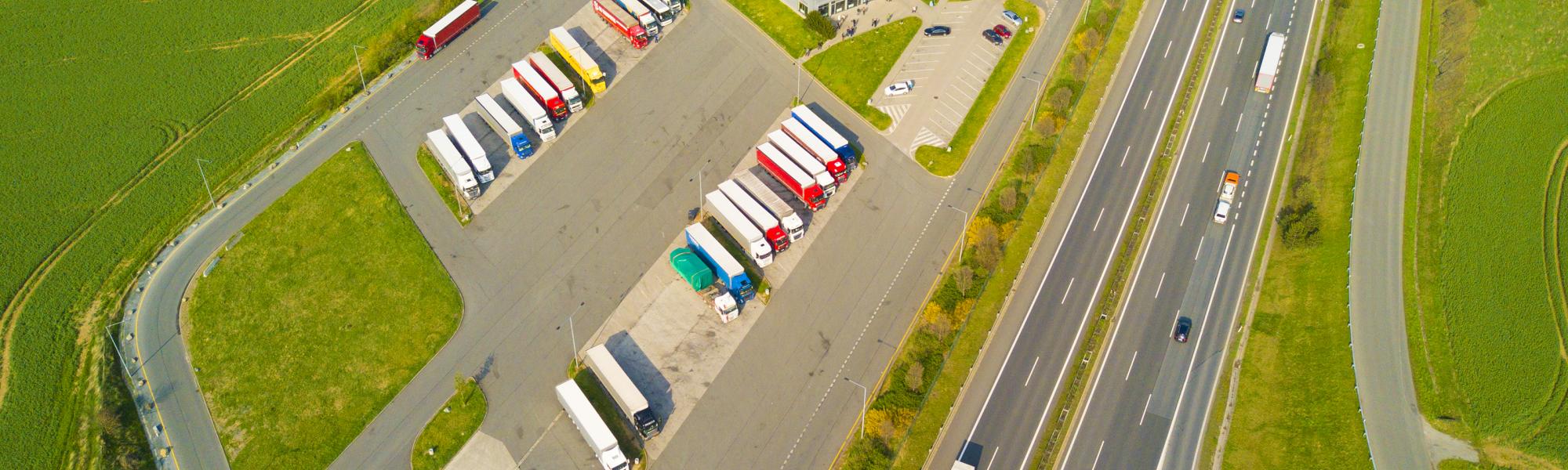 Aerial view of highway rest area with restaurant and large parking for cars and trucks