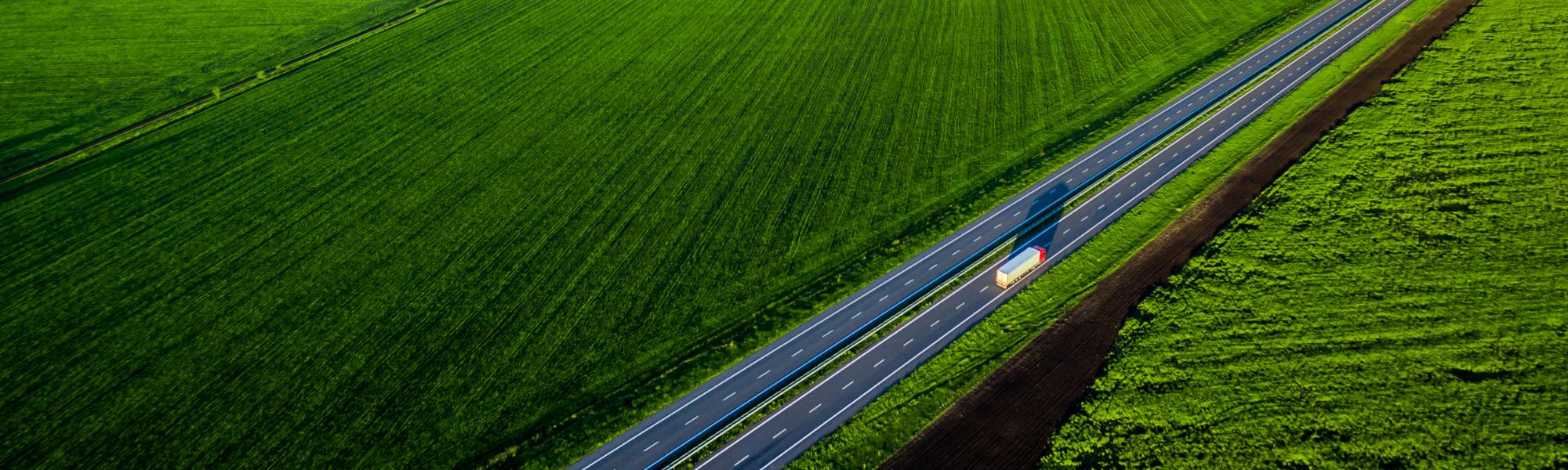 truck on a highway with a green landscape