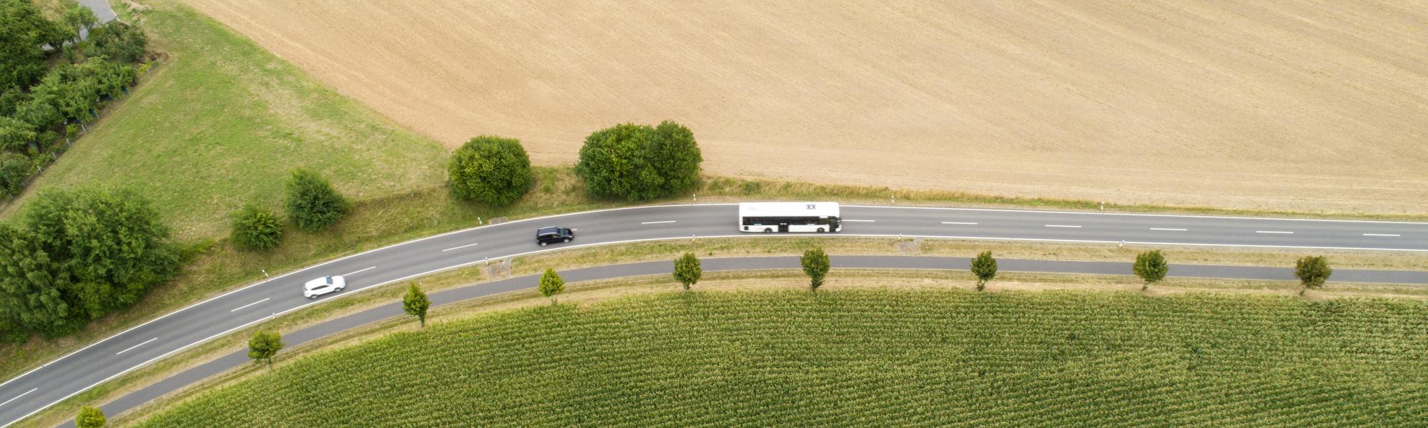 aerial view of a white coach driving on the road