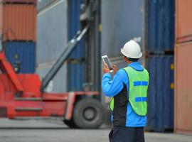 man with tablet and shipping containers